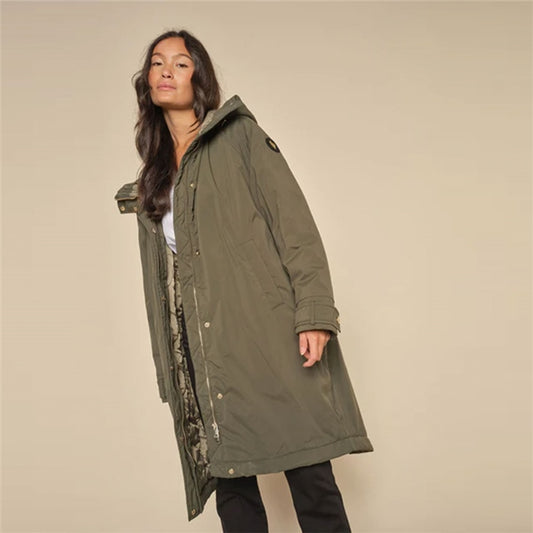 This 'Cali' parka style coat by Mos Mosh is designed with current trends and functionality in mind. Featuring a high closing collar and hood with a hidden central zip fastening and popper placket, long sleeves and pockets. It is relaxed, oversize fitting and has internal poppers at the waist to adjust if preferred for enhanced shape and a back vent for ease of movement. This coat effortlessly combines practicality with timeless elegance, crafted from high-quality insulating fabric in a khaki green shade, it