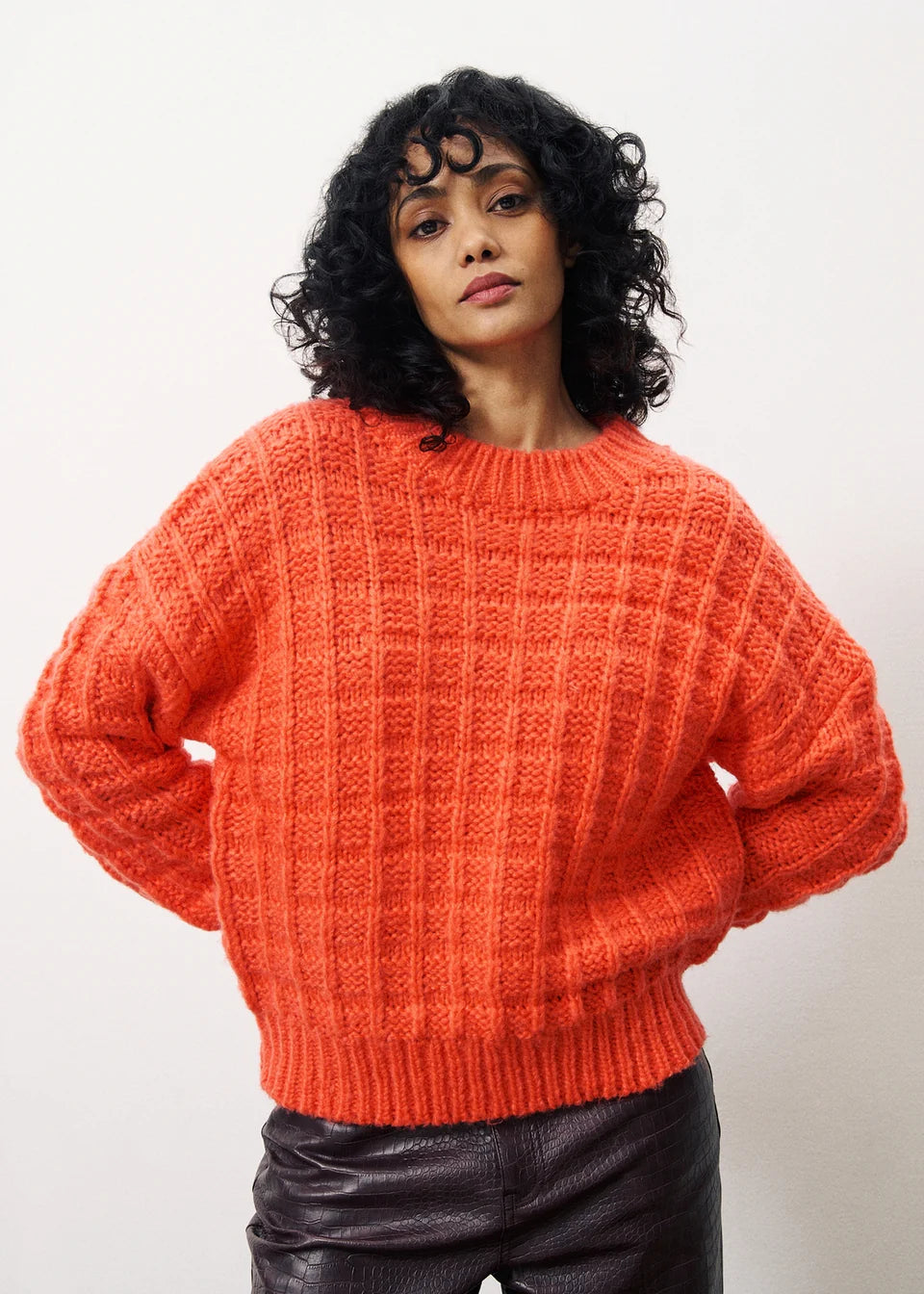 A beautiful thicker knit from our favourite Parisian brand FRNCH. This gorgeous chunky, boxy knit in a vibrant bright Coral is a fabulous Winter piece. The textured shorter knit is great with a trouser but wear over a dress to change the look. The round neck has a ribbed trim as do the long sleeves.