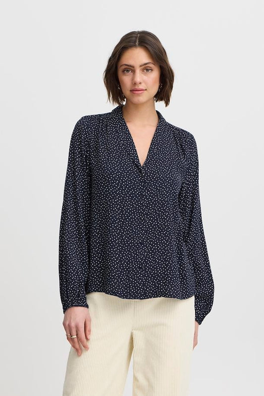 A beautiful feminine piece by Parisian brand Ateliere Reve. This gorgeous blouse in classic navy with a tiny white heart shaped print. A shawl style collar with V neck is super flattering. Long sleeves with an elasticated cuff and a rounded hem. The fabric is super soft and the fit true to size.