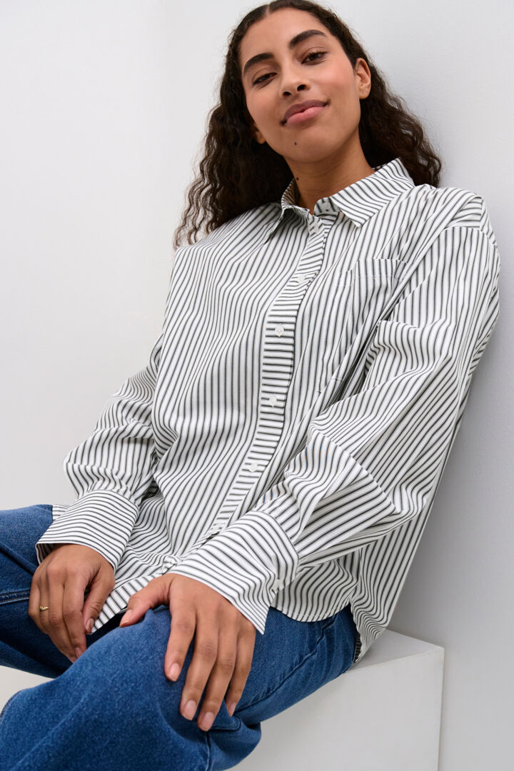 A simple oversized shirt in monochrome colours from KAFFE clothing. This simple shirt can be worn in lots of different ways depending on how you like to style it. Wear with a chunky knit through winter for that cool chic look or layer over a T shirt or stylish blazer. It has a standard size shirt collar, button cuffs and a single breast pocket. The fit is very oversized.