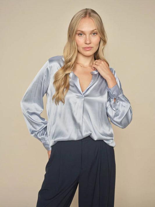 This satin blouse from Scandi brand Mos Mosh is inspired by the nostalgic 70s. It has a loose silhouette and is designed with a trendy V neck, billowy sleeves, collar, and buttoned cuffs. We think it looks amazing with everything from tailoring to skirts and jeans. The fit is true to size.