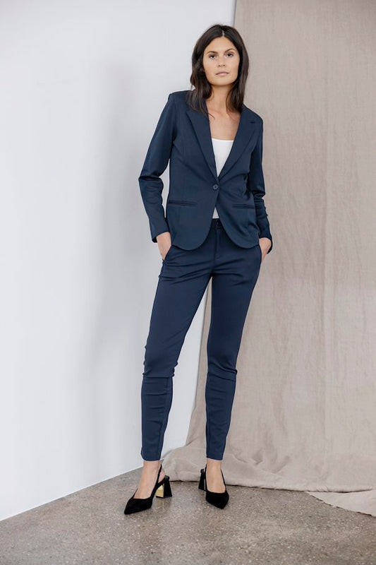 A pull on trouser from Scandi brand Fransa in a classic navy blue for Spring . A great tapered leg style perfect with a heel or a trainer. Complete with a half elasticated waist and pull tie for a neat fit. Slanted pockets to the front complete the look . The fit is true to siz