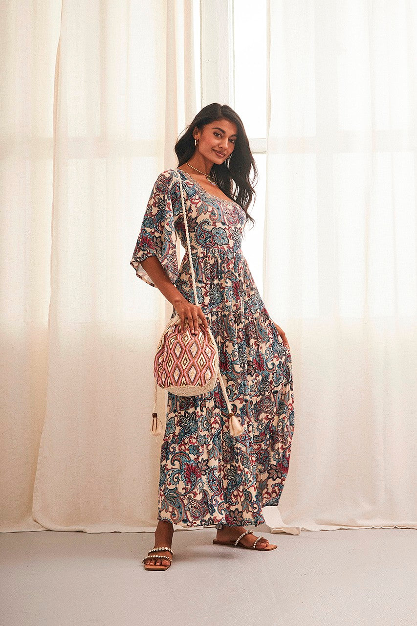 Express your passion for the stunning Nun Dress from NKN Nekane! This beautiful piece features a long paisley print, asymmetrical 3/4 sleeves, and an open back with a wide tie closure, creating a feminine and playful look. The embroidered detail on the collar is a lovely touch, adding to the dress's overall charm.