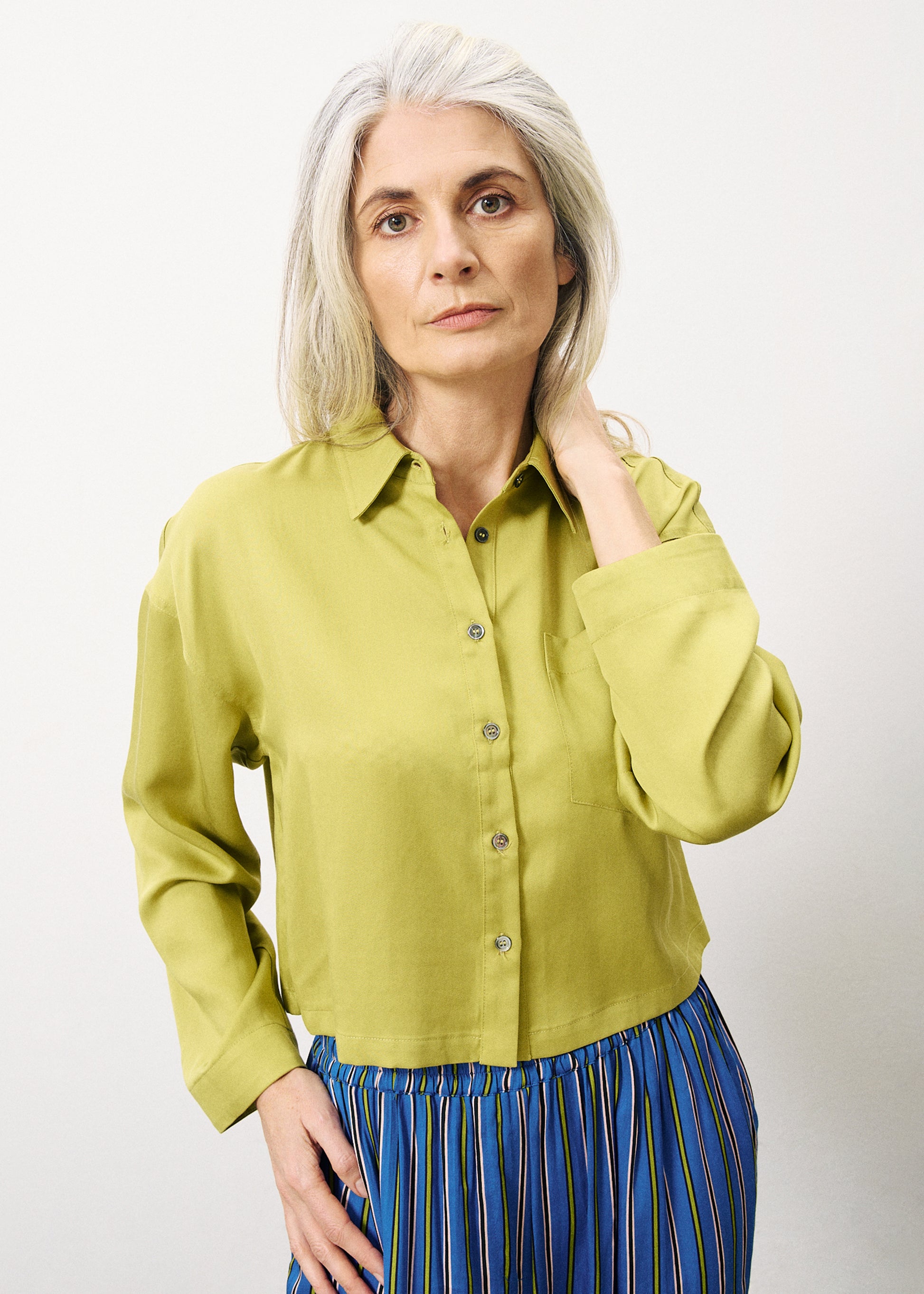 This great cropped shirt from Parisian brand FRNCH in this striking Olive colour works beautifully with denim. A shorter length with a standard shirt collar and long sleeves with a single button at the cuff. The buttons on the front are in a contrasting colour. There is a single breast pocket and it has a straight hem. The boxy fit is true to size.