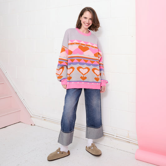 The Poppy jumper from CARA & THE SKY is here to bring the love! In a stunning intarsia knit, this oversized jumper features a multicolour heart design where bright pink, orange and soft pink hearts meld. Inspired by our love for colourful jumpers, the intarsia stitch method creates the heart pattern within the knit for a seamless finish.