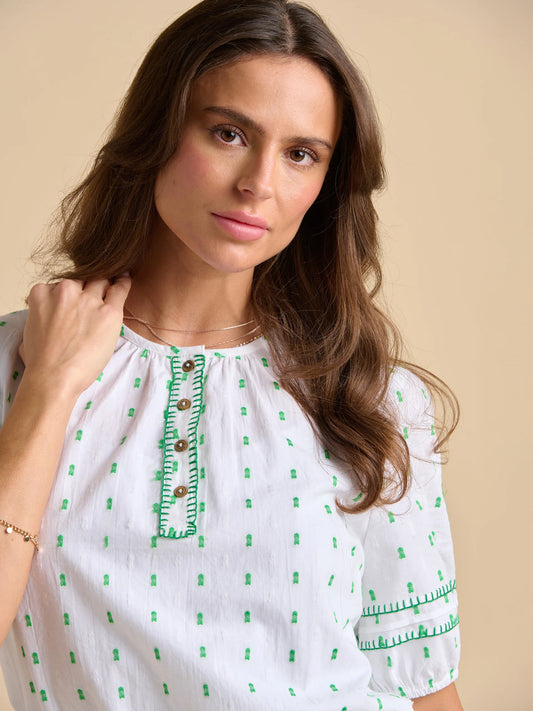 This white and green embroidered blouse&nbsp; from BRAKEBURN captures bohemian charm with its puff sleeves with elasticated cuffs. Perfect for a meadow stroll or countryside getaway, pair it with a straw hat for a laid-back, carefree look.