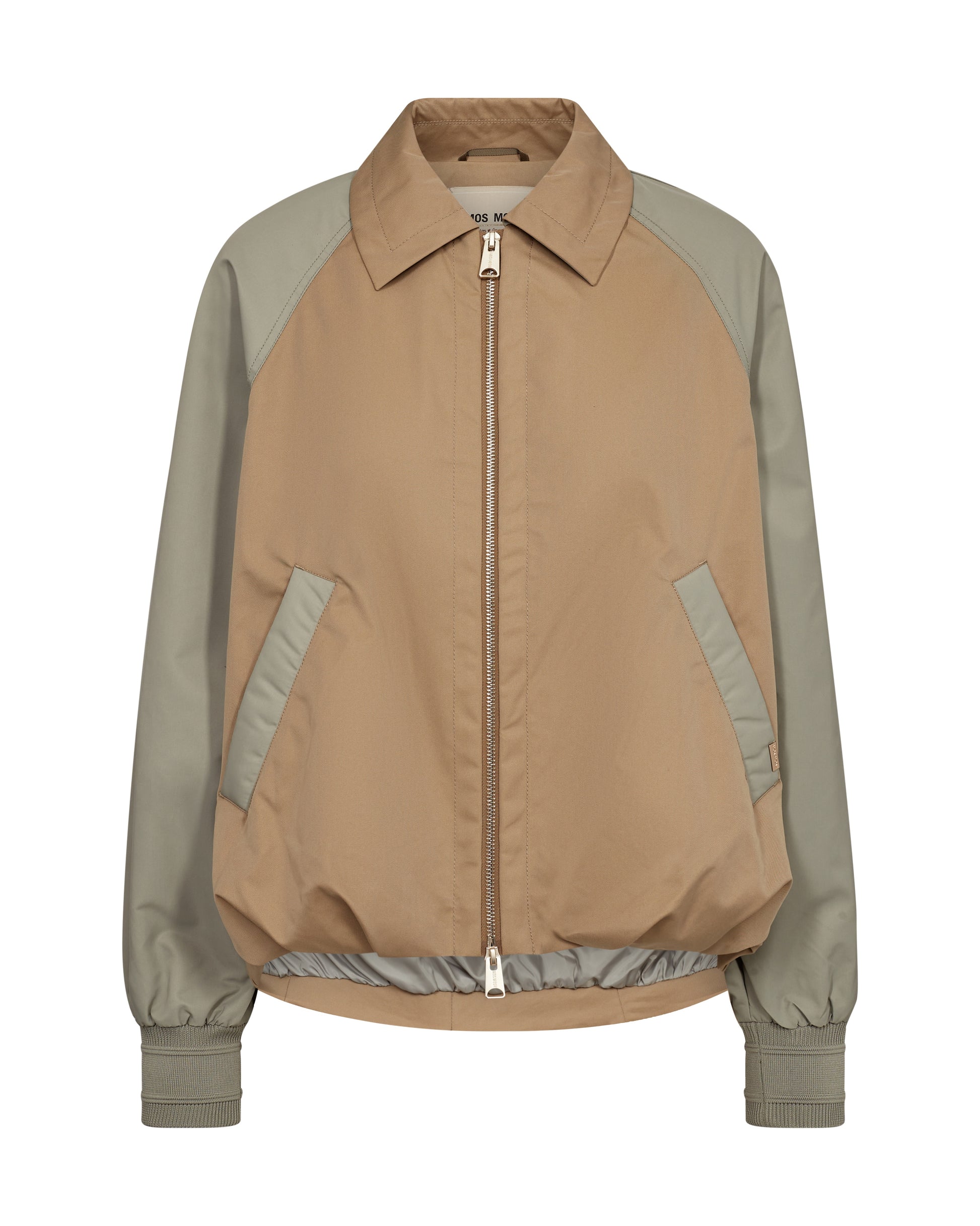 Elevate your spring wardrobe with this stunning colour-blocked bomber jacket from MOS MOSH, blending trench coat and bomber jacket elements. It features a two-way zipper, slant pockets, elasticated cuffs, and an elasticated bottom for a voluminous silhouette. The contrast-coloured sleeves and pocket tape add a bold touch, making it perfect for chilly spring days.