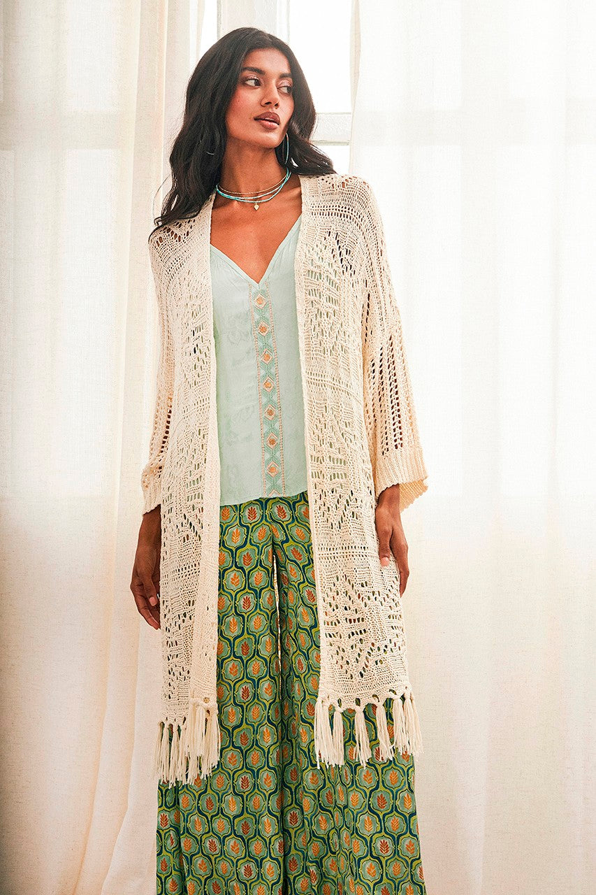 Elevate your wardrobe with NKN Nekane's gorgeous knitted kimono, featuring stunning fringe detail and a neutral colour that can be effortlessly paired with any outfit. This versatile piece can be draped over dresses or co-ords for a chic and bohemian look, or paired with jeans for a casual yet stylish ensemble. With a long length and open crochet design, this cardigan is sure to make a statement with its dropped shoulder and bracelet length sleeves.